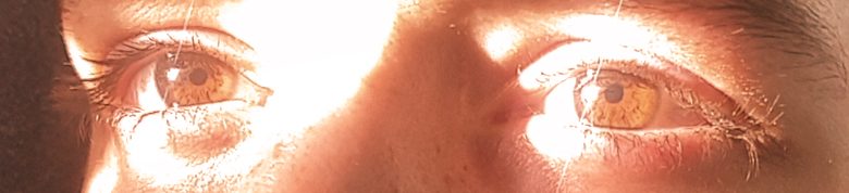 Nahaufnahme von zwei braunen Augen mit starkem Lichtschein.
